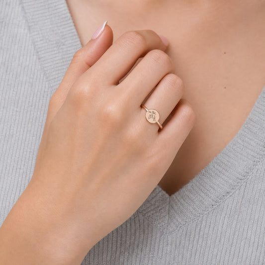 Custom round botanical signet ring on hand