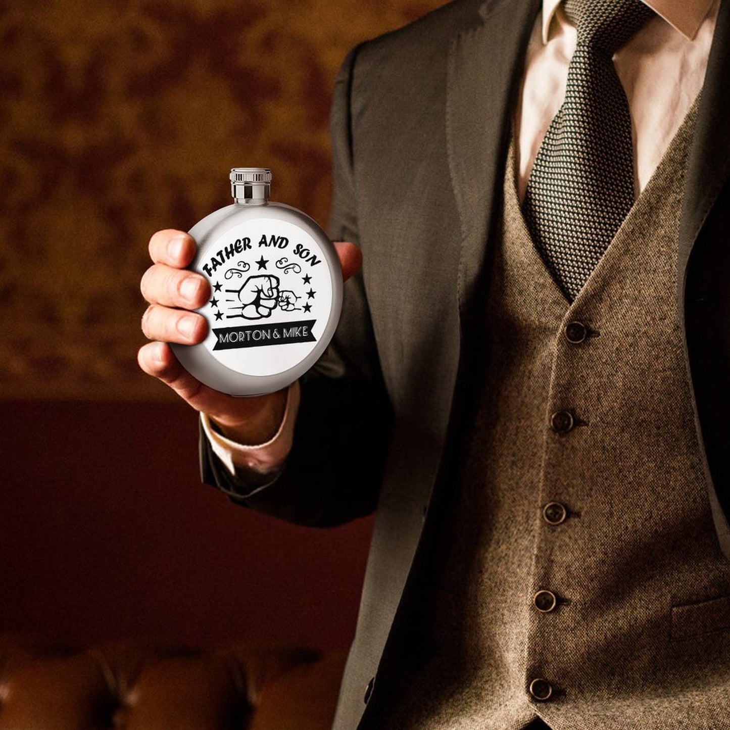 Man in a suit holding a custom personalized Father Son stainless steel hip flask.