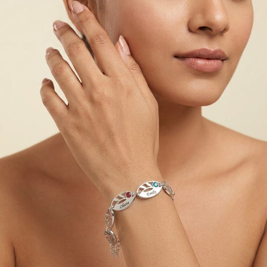 Woman wearing a personalized silver leaf bracelet featuring custom engraved names and colorful birthstones