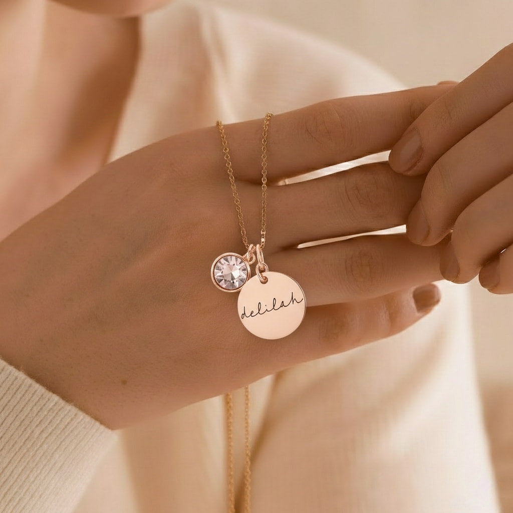 Rose gold personalized name necklace with clear birthstone, on model.