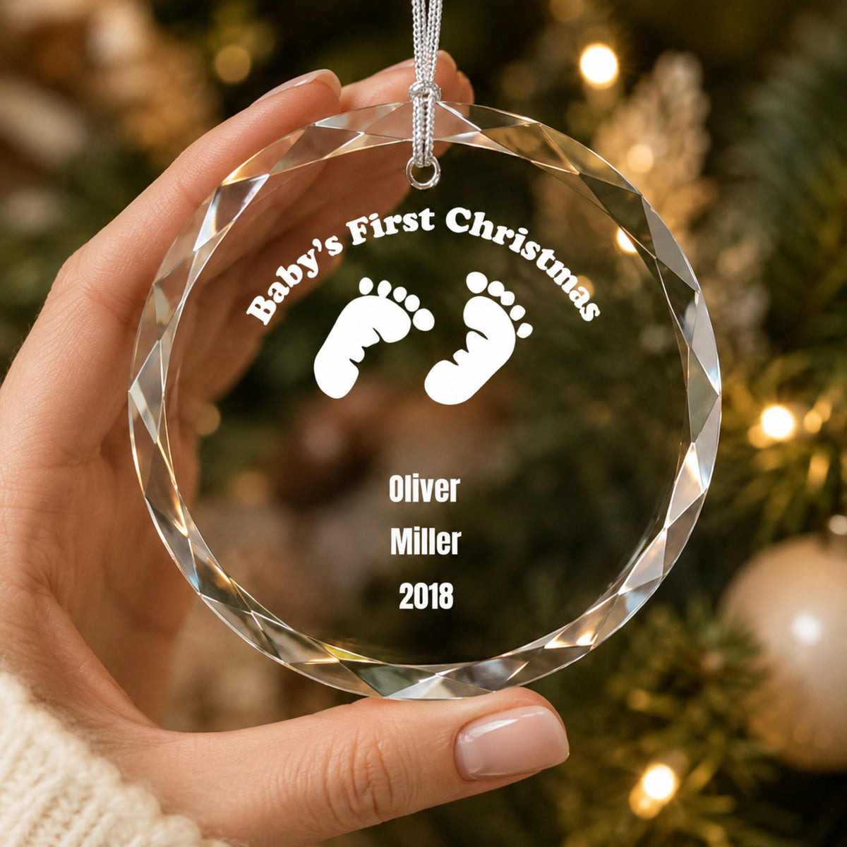 Baby's First Christmas Footprint Design personalized glass ornament in hand scale view