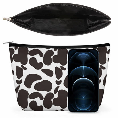 Cow Print Toiletry Pouch shown next to a phone for size comparison, highlighting the interior space.