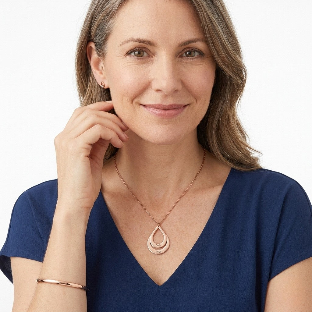 Woman wearing a personalized rose gold family name pendant.