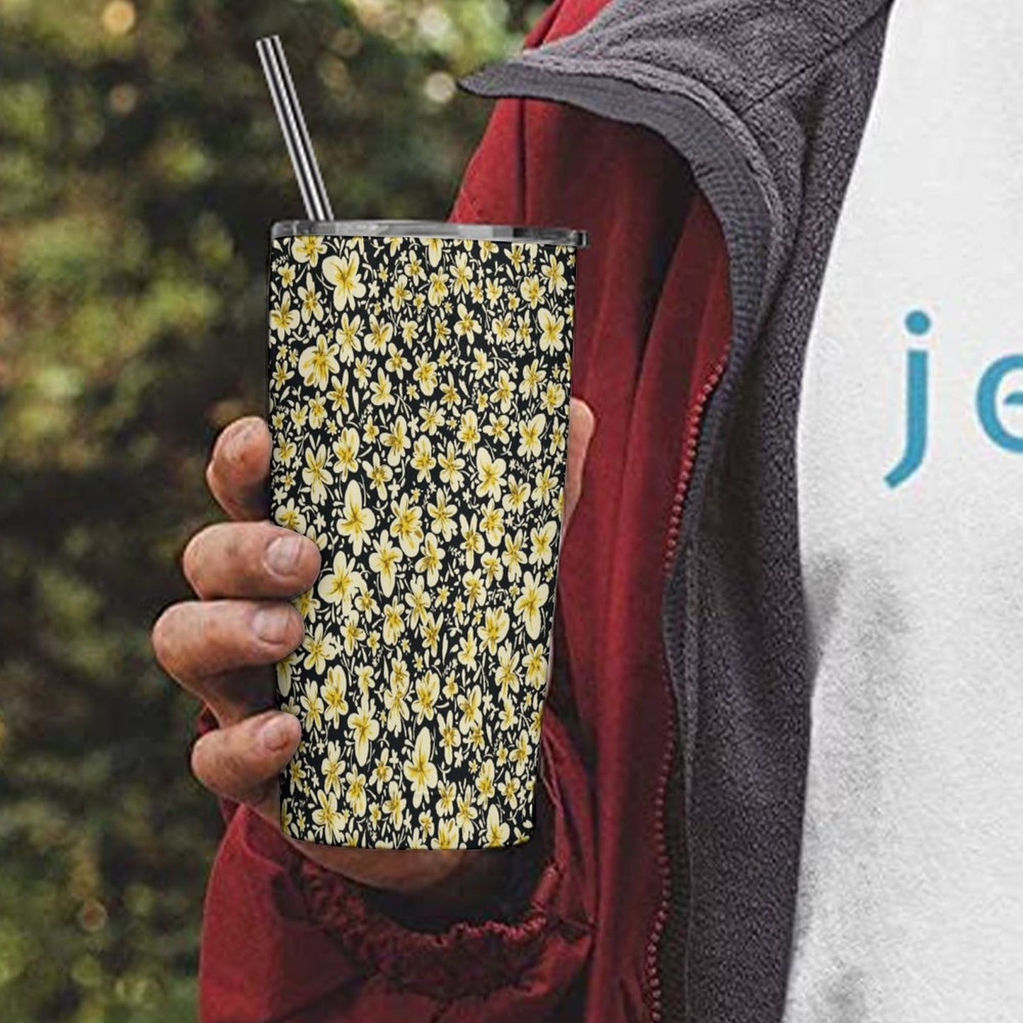 Custom All Over Print 20oz Tumbler, stainless steel, held by hand outdoors.