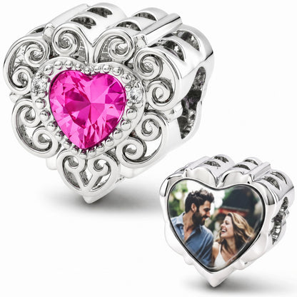 silver heart charm decorated with filigree scrolls, a vibrant pink heart gemstone, and a custom photo locket
