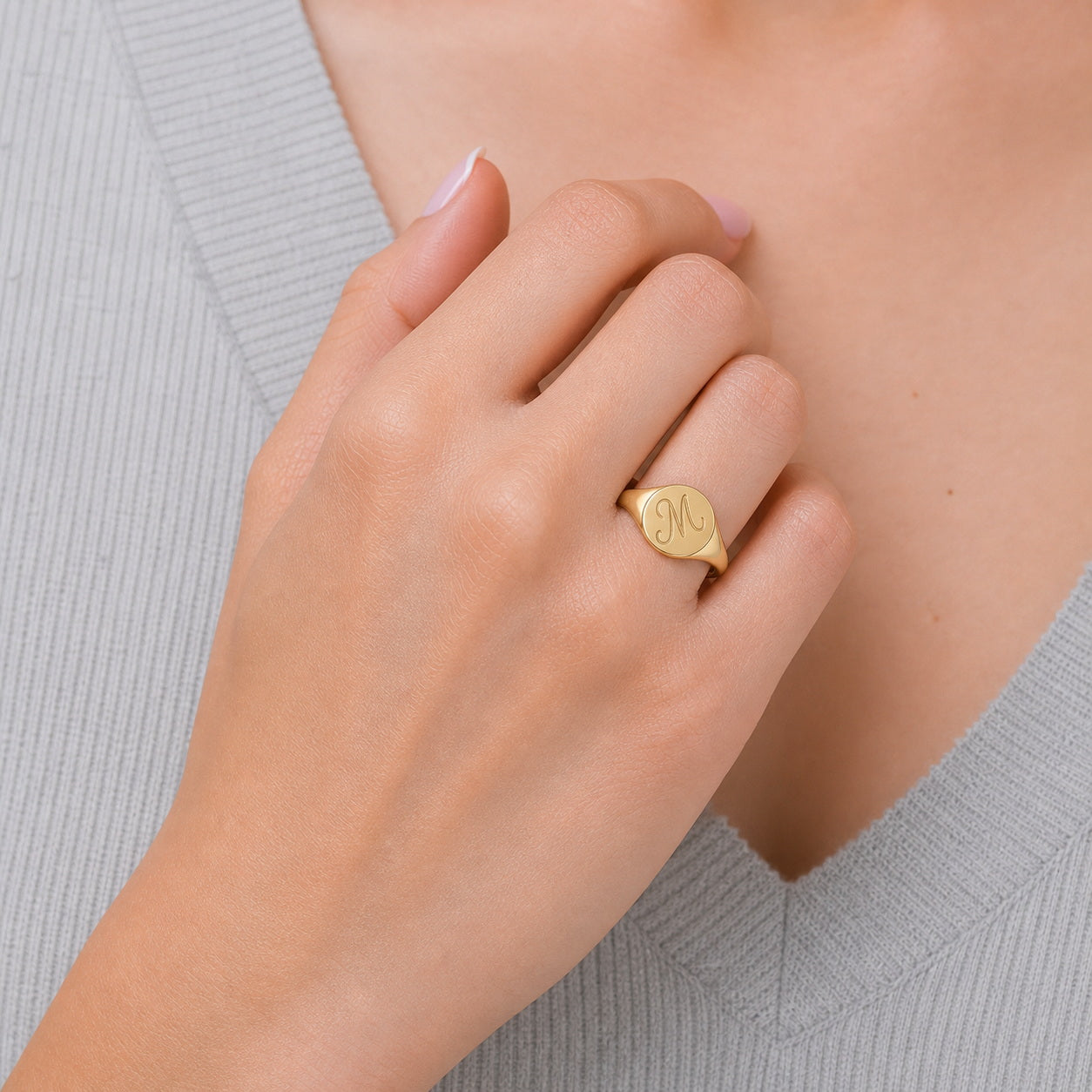 Custom initial signet ring on hand