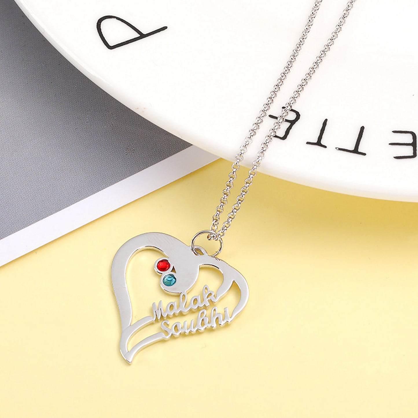 Close up of sterling silver customized jewelry heart necklace gift.