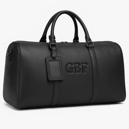 Close-up of the custom embossed monogram on a large black leather travel or gym bag.