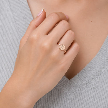 Custom round botanical signet ring on hand