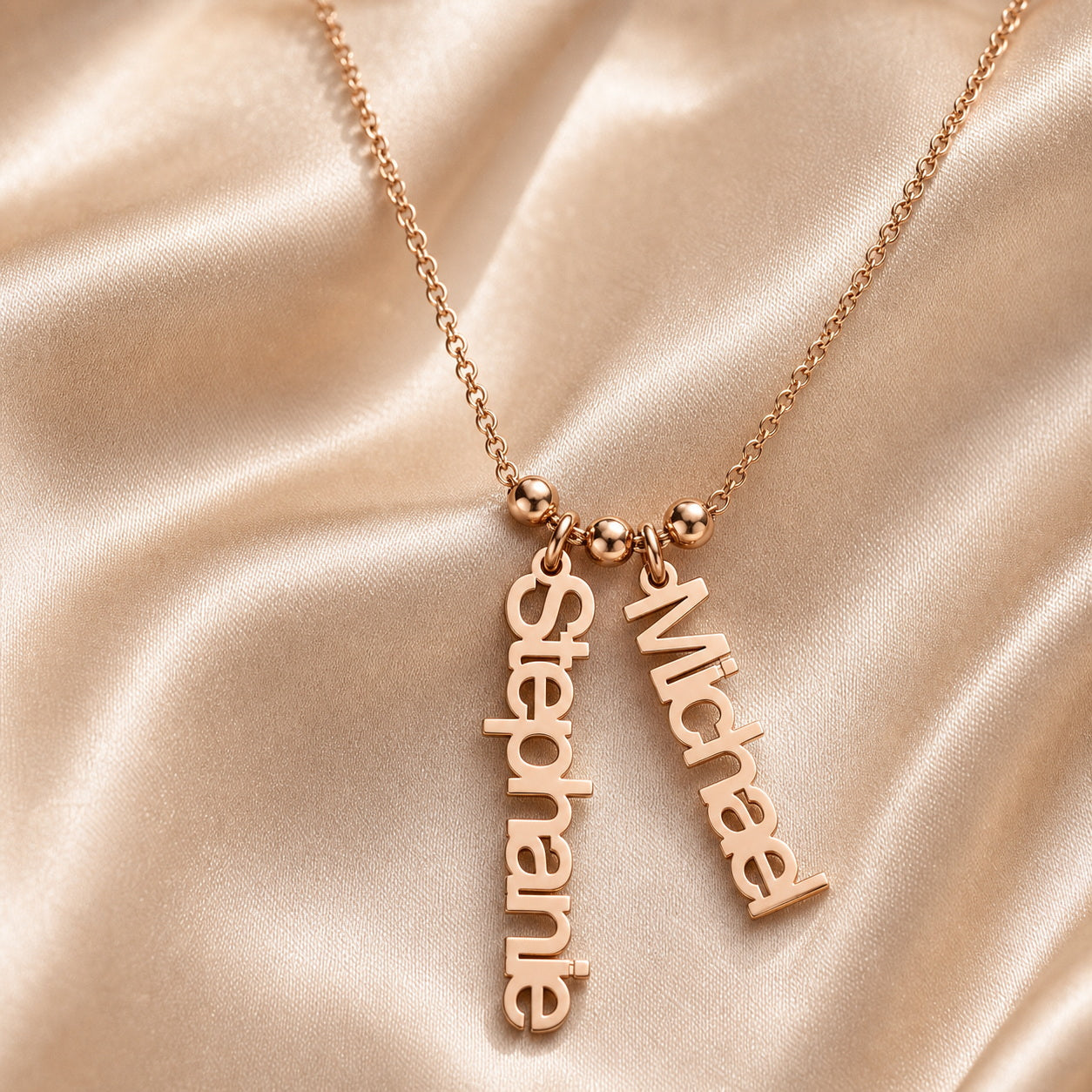 Rose gold custom two name charm necklace on satin fabric