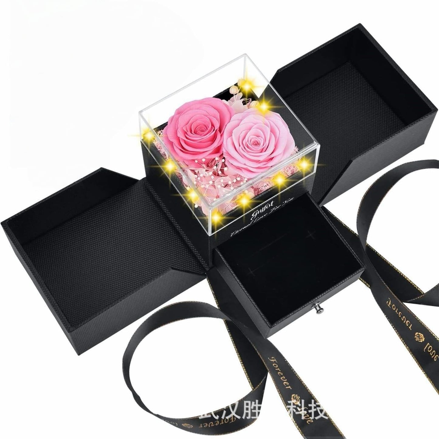 Two-tone pink preserved roses in a black gift box with gold-rimmed ribbon.