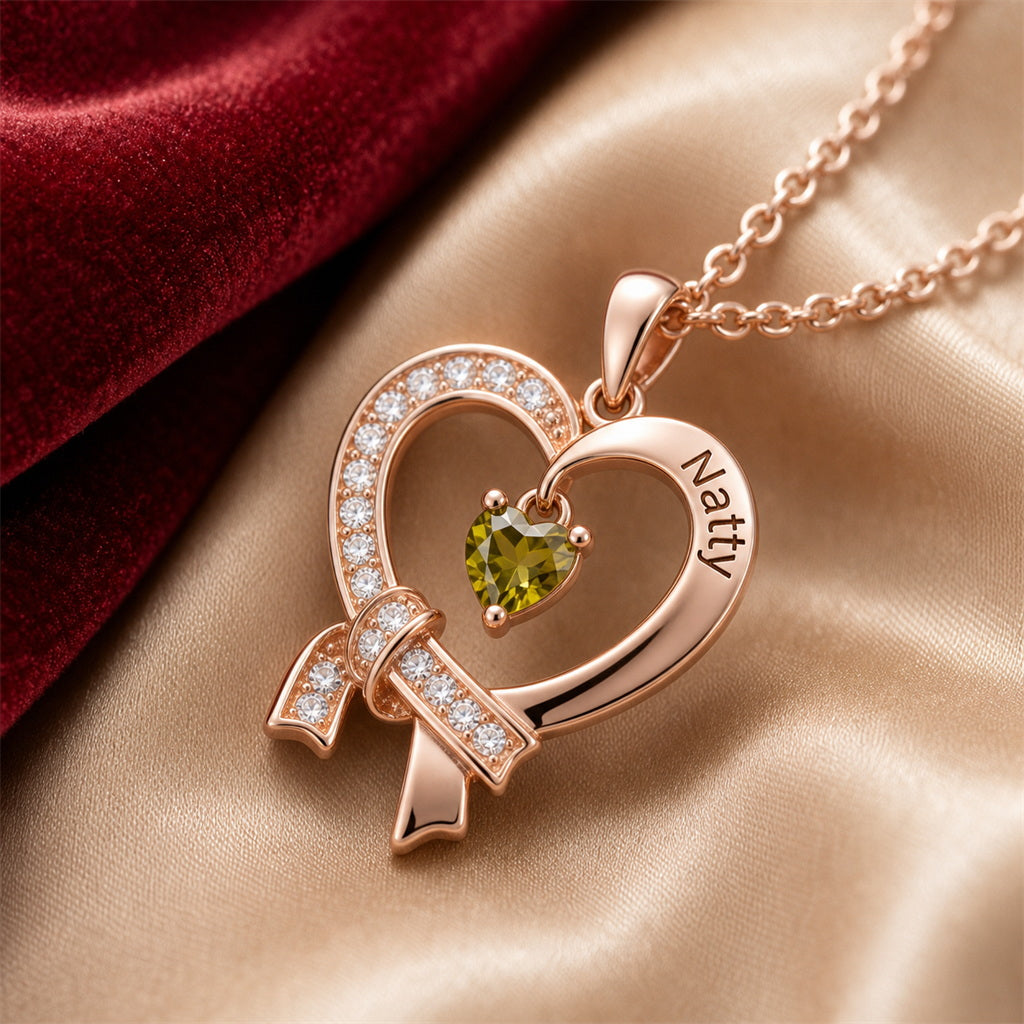 Engraved heart ribbon necklace closeup on champagne silk