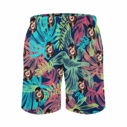 Personalized men's funny face beach shorts, tropical floral pattern.