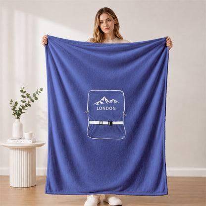 Woman holding a large blue personalized plush blanket.