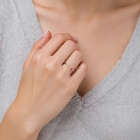 Person wearing a custom birthstone initial ring in 925 silver.