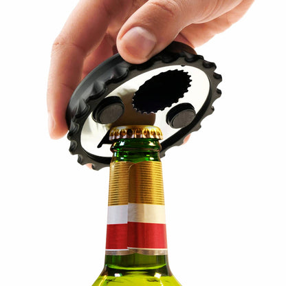 Hand using the custom magnetic bottle opener to open a beer bottle; demonstrating the product's function and unique bottle cap shape.