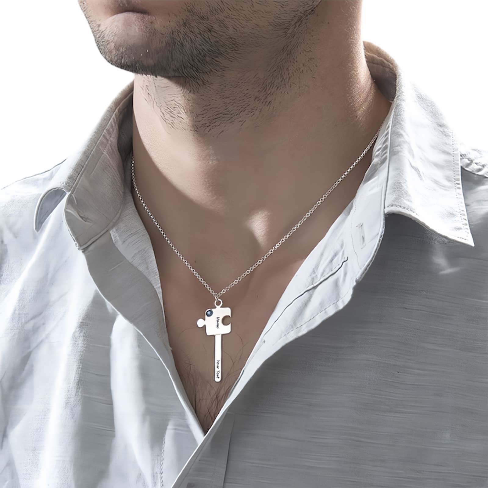 Man wearing personalized sterling silver puzzle key necklace with custom name, text, and blue simulated birthstone. Ideal partner gift.