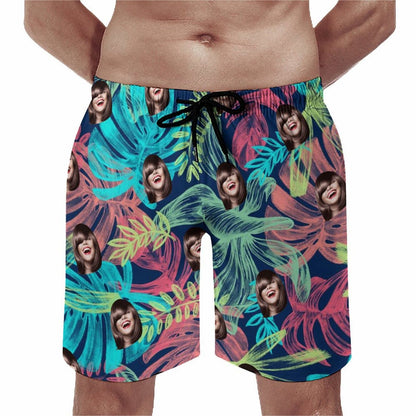 Men's funny face swim trunks model view. Custom tropical floral shorts.