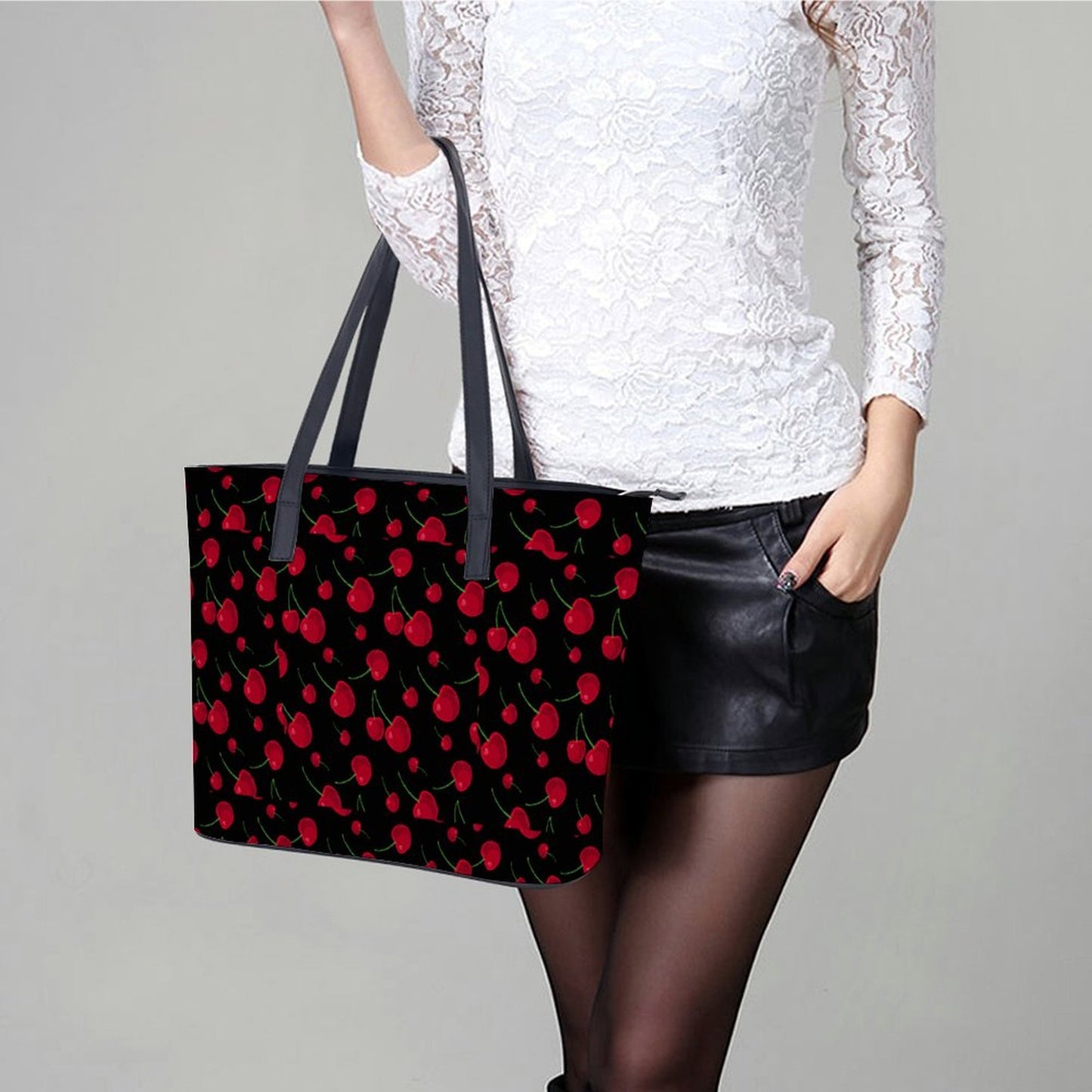 Woman with cherry print tote purse in street view. White dress.