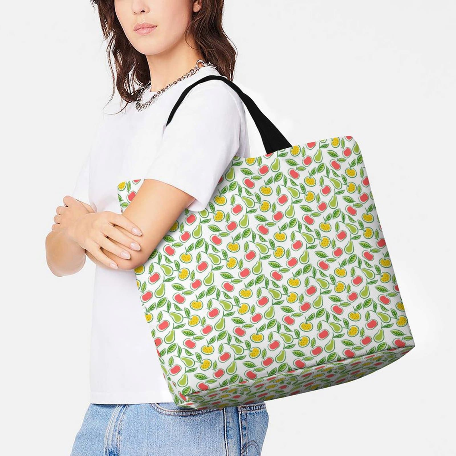 Model wearing large reusable grocery shopping tote bag with fruit print design.