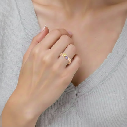 Model wearing personalized rose gold heart ring with purple and yellow gems.