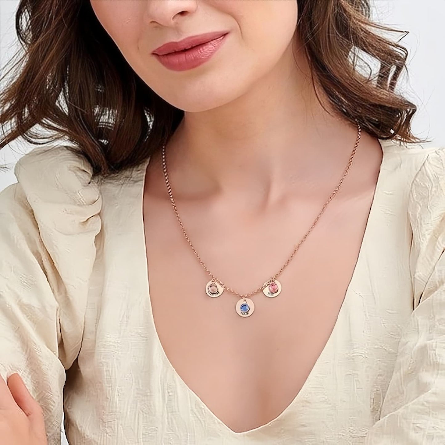 Woman wearing personalized silver birthstone disc necklace with custom engravings.