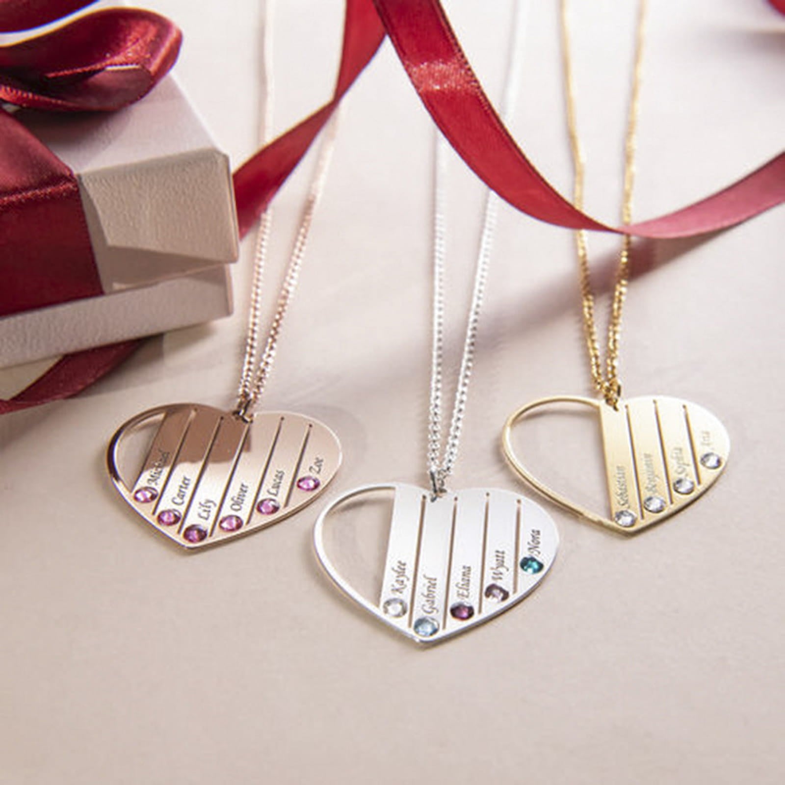 Multiple heart family name birthstone necklaces display. Silver, gold, rose gold options.