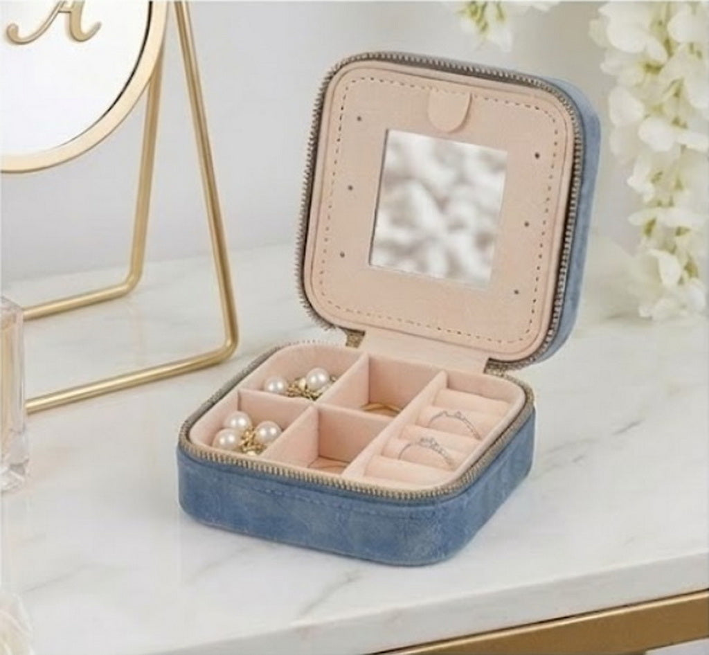 Open blue velvet jewelry box with internal mirror