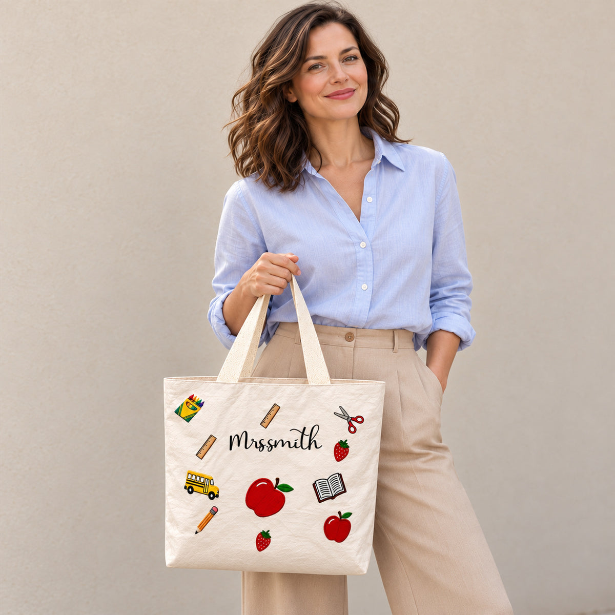 Personalized apple school icons teacher tote bag with custom name, showing the custom name and printed design.