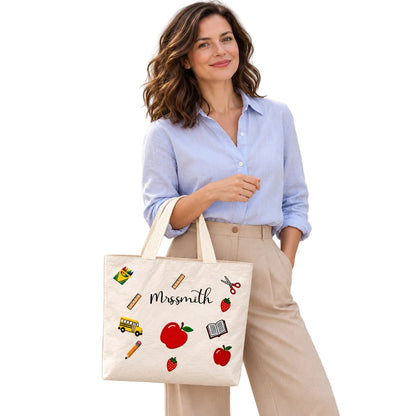 Personalized apple school icons teacher tote bag with custom name, carried on a model’s forearm with the personalized design visible.