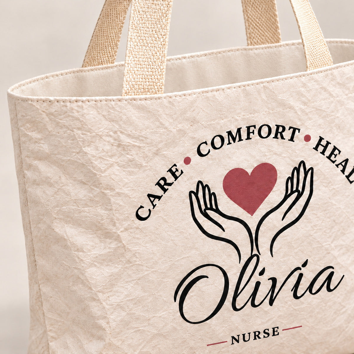 Close-up of the cream Care Comfort Heal tote showing its crinkled texture and woven handle.