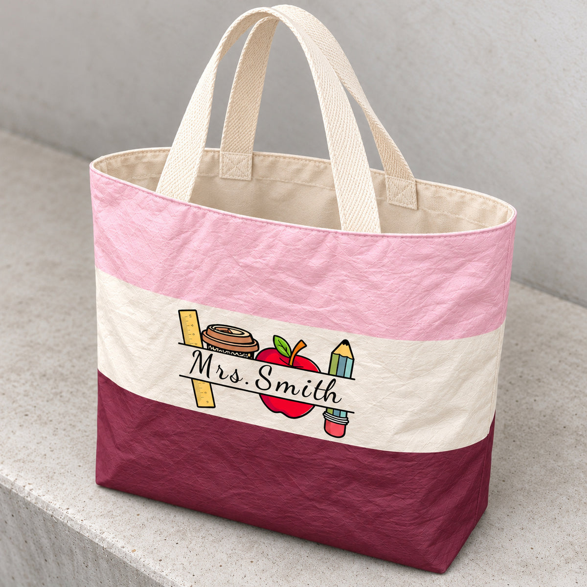 Angled detail of the crinkled colorblock teacher tote, cream canvas lining, woven handles and Mrs. Smith print.