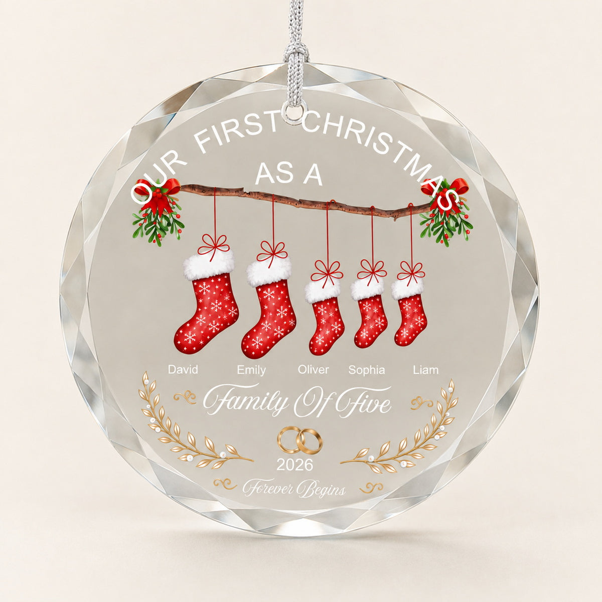 Personalized family Christmas ornament with five stockings, names, and year displayed on a clear round keepsake