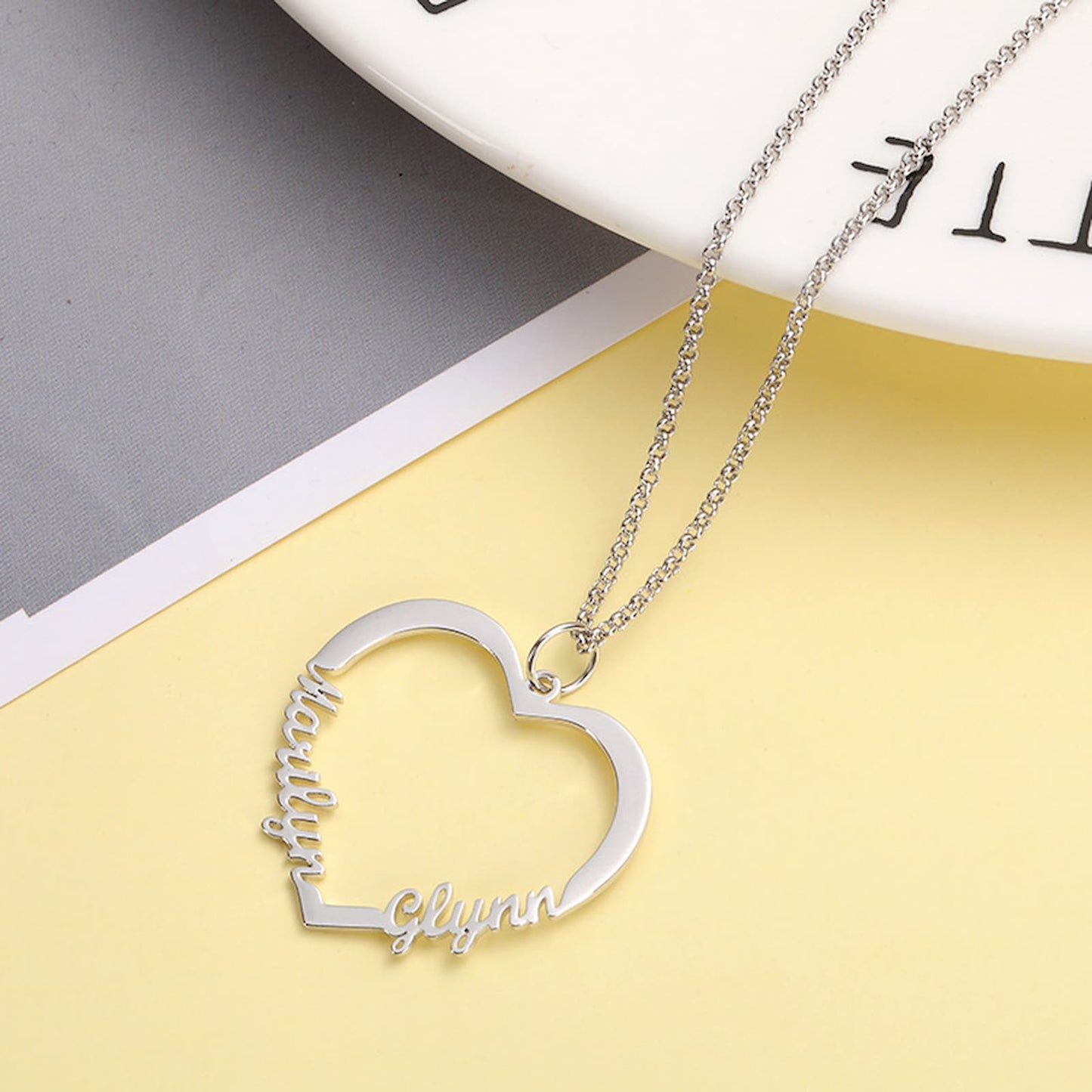Personalized heart necklace flat lay. Sterling silver custom names.