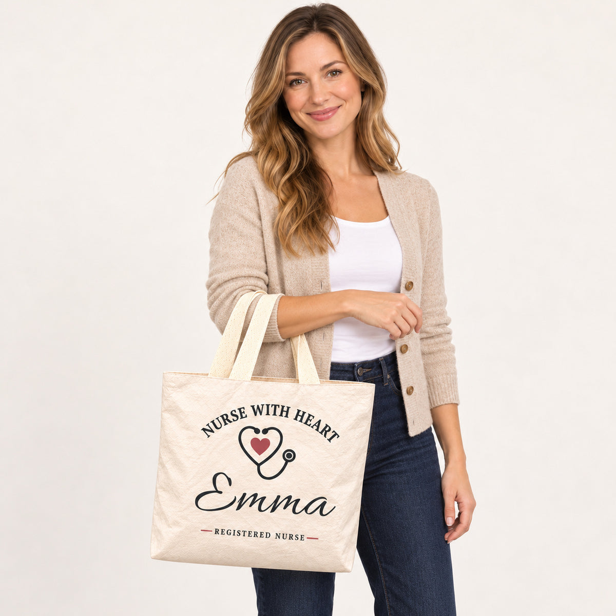 Cream Nurse With Heart tote personalized with Emma, carried on a model¡¯s forearm with the printed front visible.