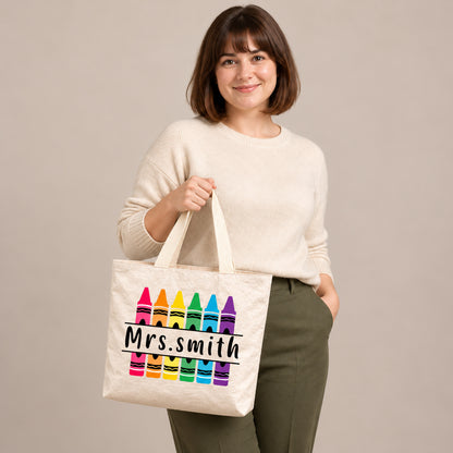 Personalized rainbow crayon teacher tote bag with custom name, showing the custom name and printed design.