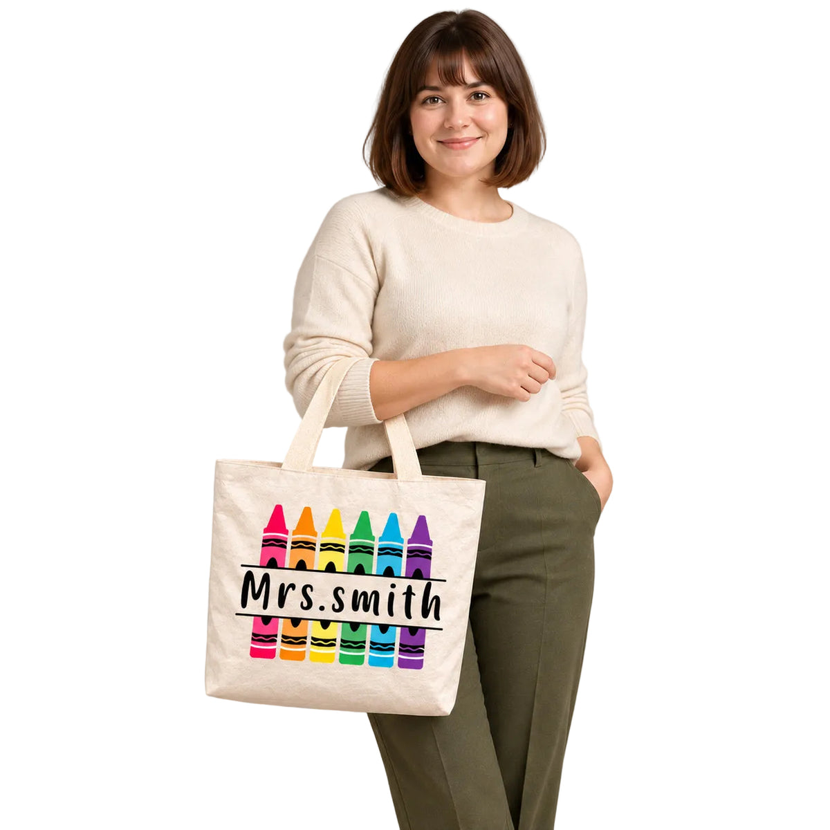 Personalized rainbow crayon teacher tote bag with custom name, carried on a model’s forearm with the personalized design visible.