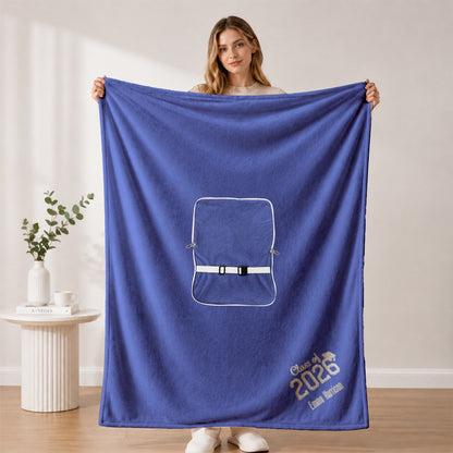 Woman holding open royal blue custom graduation blanket with embroidery name and school.