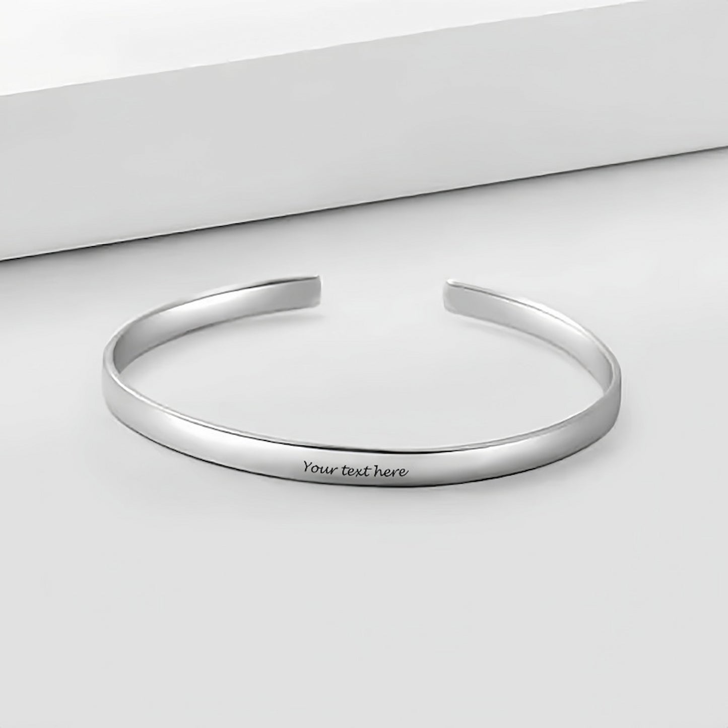 Personalized sterling silver cuff bracelet flat lay. Custom engraved text for men.