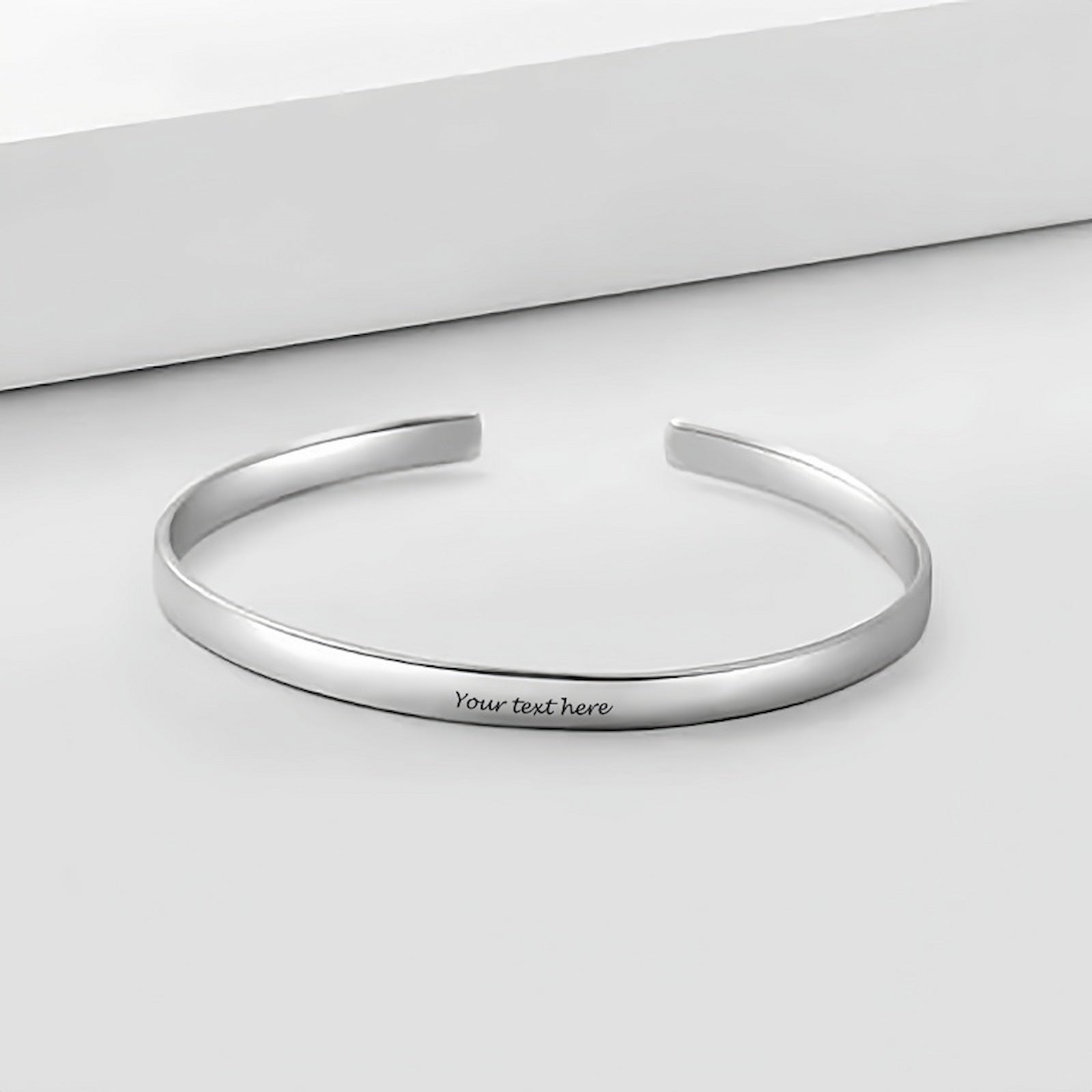 Personalized sterling silver cuff bracelet flat lay. Custom engraved text for men.