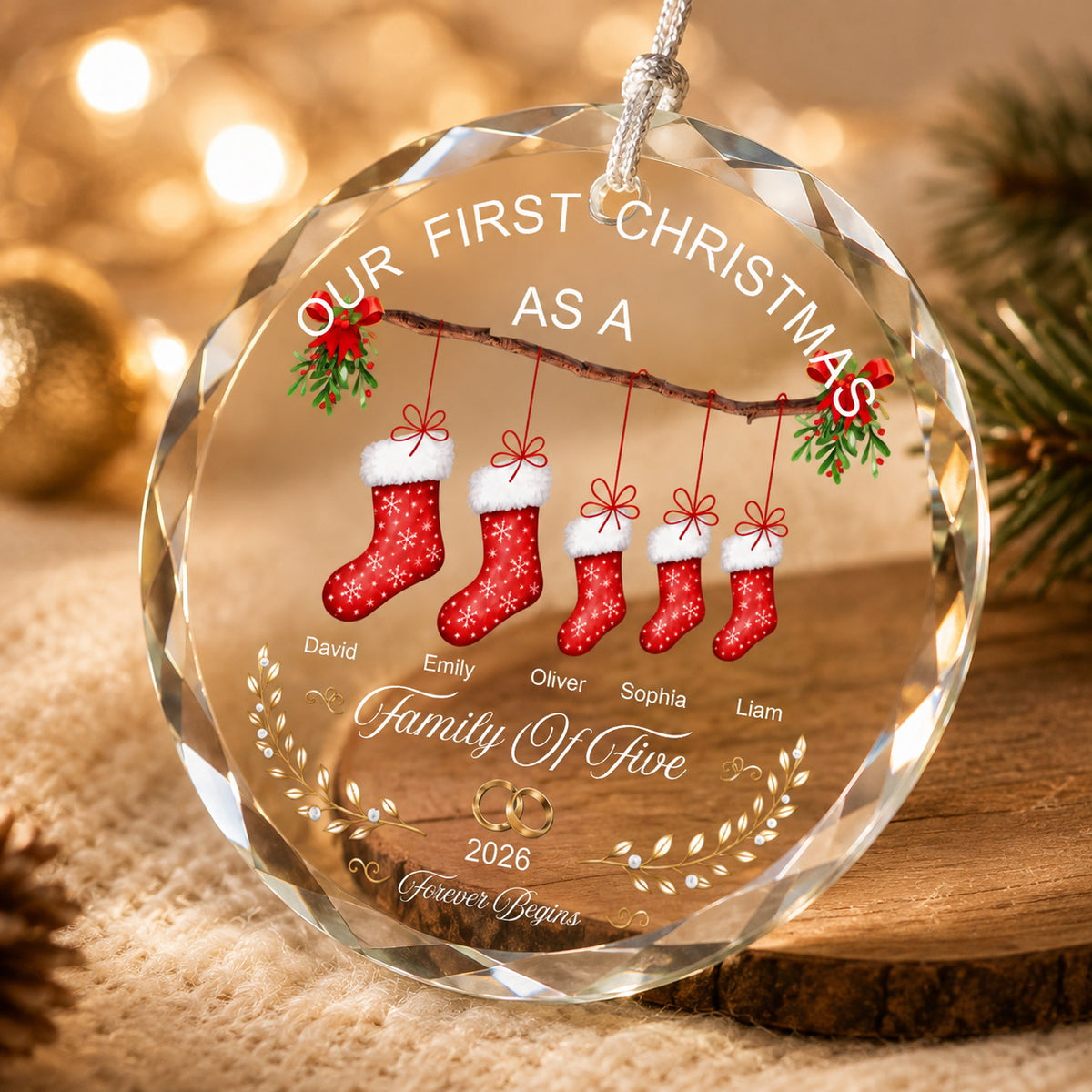 Close-up of a personalized family Christmas ornament showing clear faceted edges, printed stocking design, and festive details