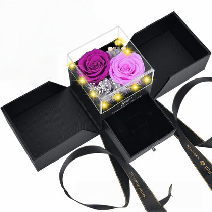 Purple and pink eternal roses in a jewelry box with warm LED fairy lights.