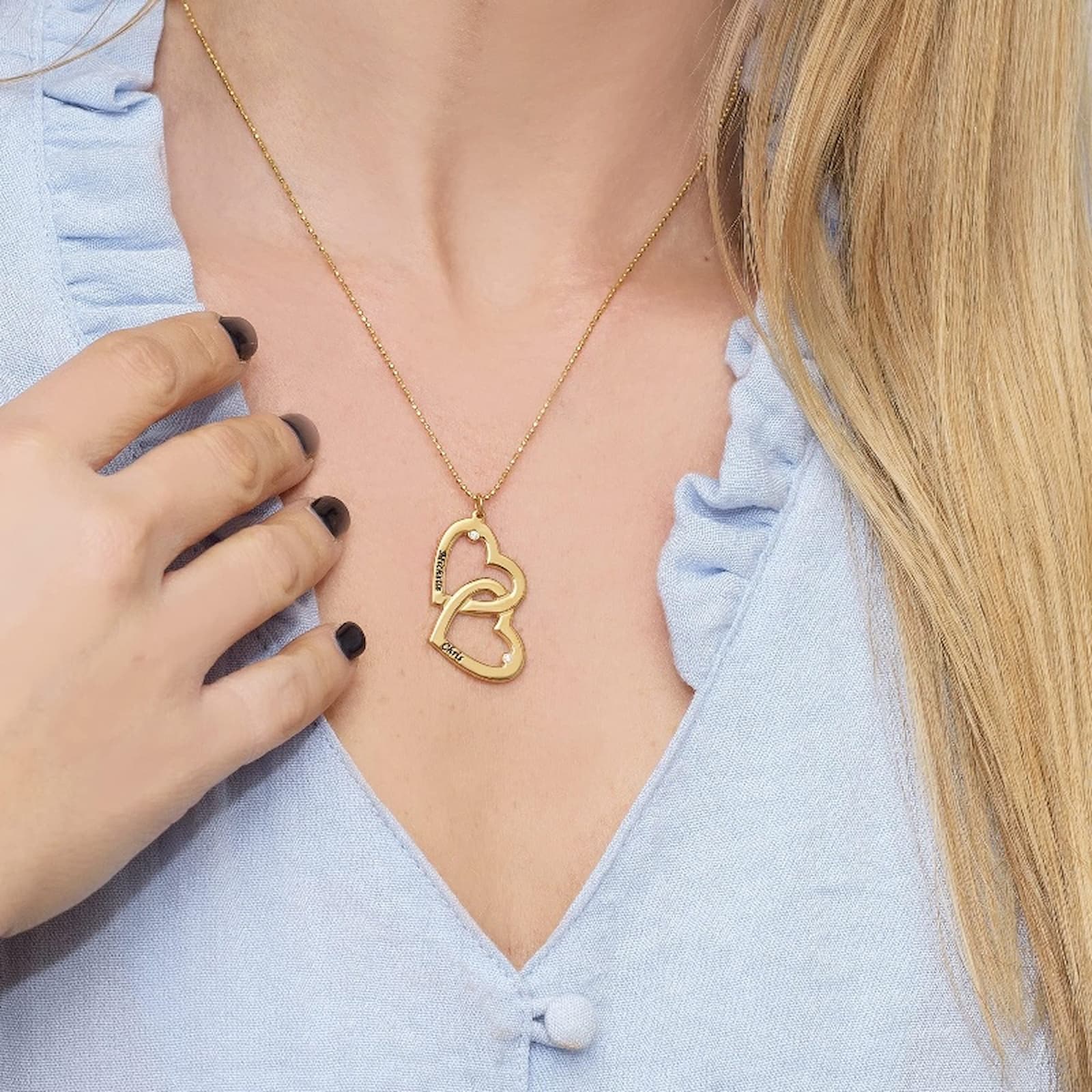 Rose gold double heart name necklace worn by a model, showing the size and fit of the custom jewelry.