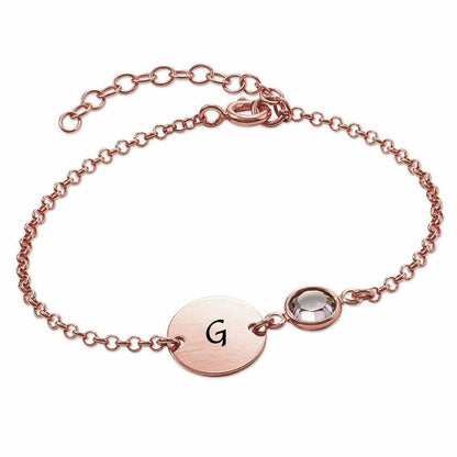 Rose gold personalized initial bracelet. Coin disc with letter G, birthstone accent.