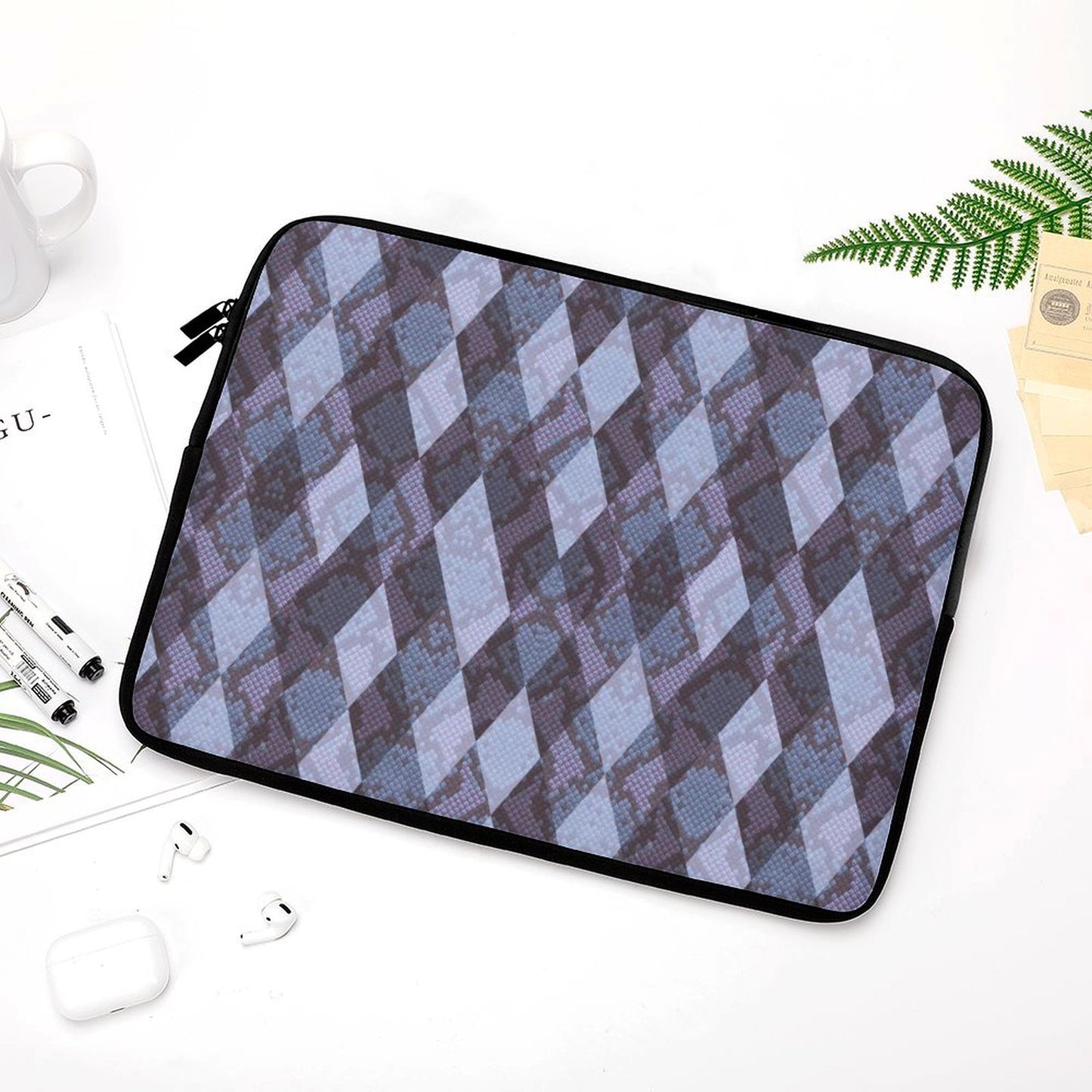 Shockproof Notebook Case with diamond pattern on a white desk with headphones.
