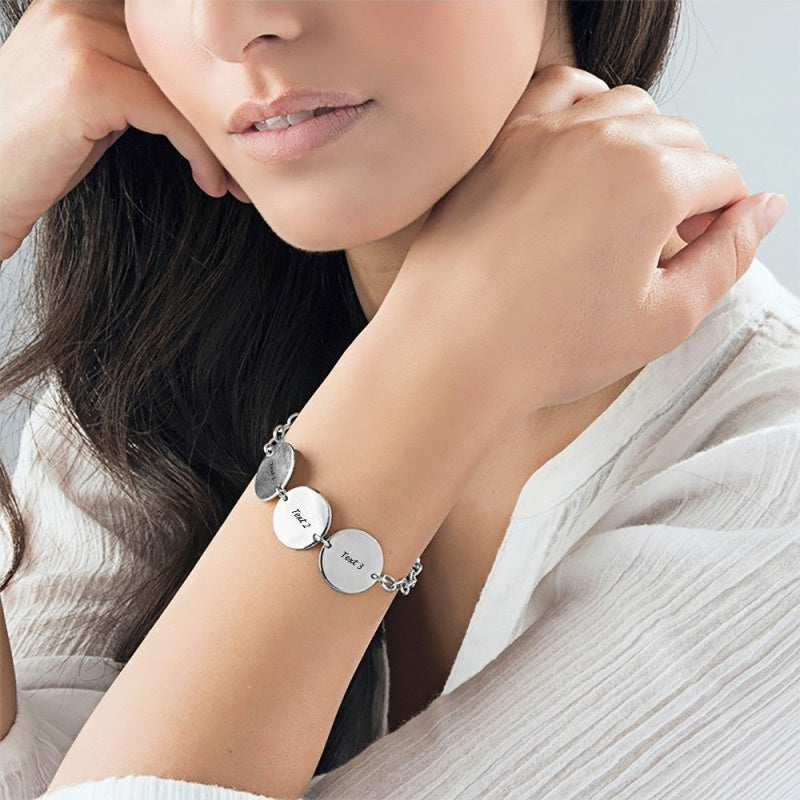 Silver engraved name disc bracelet worn by a woman. Personalized sterling jewelry.