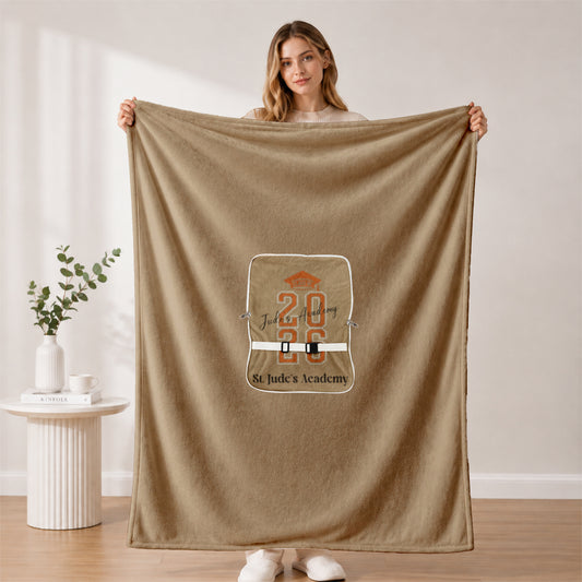 Woman holding full 2026 grad blanket in minimalist room.