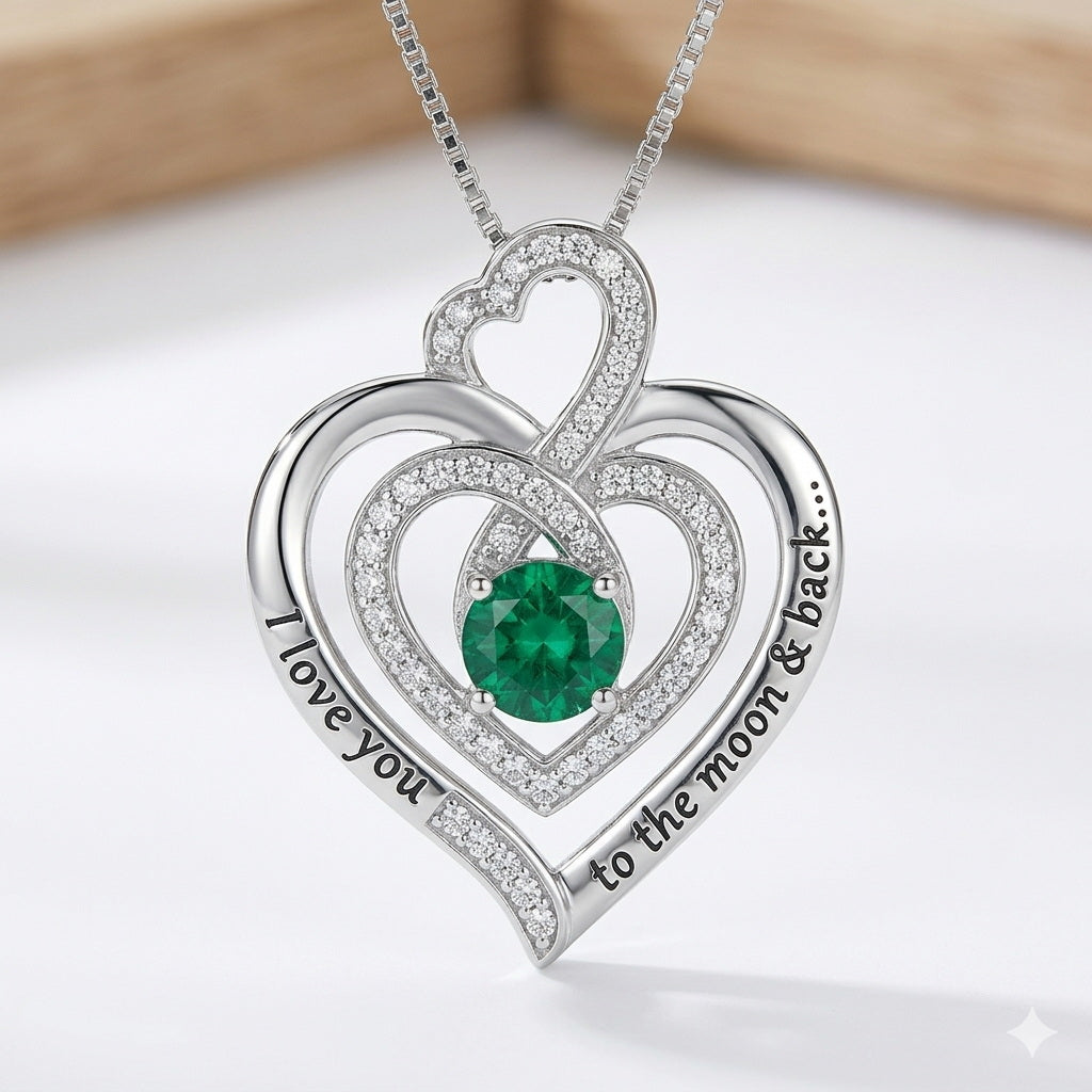 Silver triple heart necklace with a large green stone.