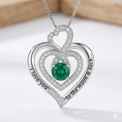 Silver triple heart necklace with a large green stone.