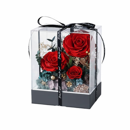 Luxurious preserved red roses arrangement displayed in a clear acrylic display box with a silver base.
